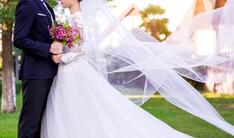 Side view of wedding couple standing at lawn